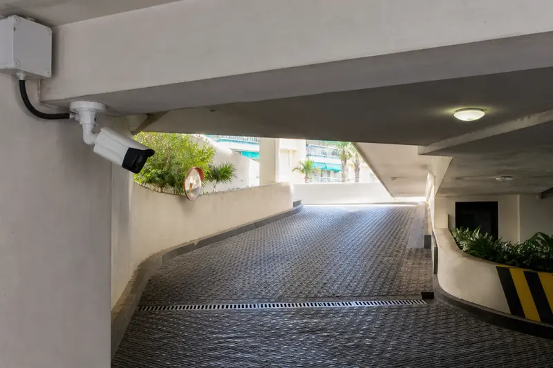 Weatherproof parking-ramp camera aligned along the vehicle approach.