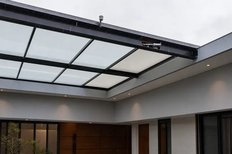Rain sensor and concealed actuator automate a villa atrium skylight.