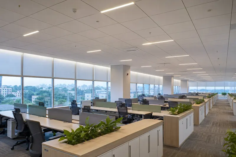 Daylight-linked open office coordinates motorized blinds, ceiling sensors and zoned lighting.