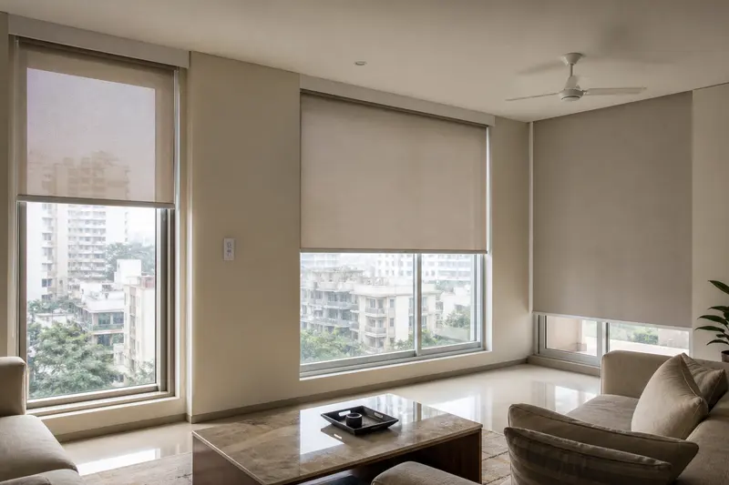 Three automated roller shades modulate daylight across an urban apartment living room.