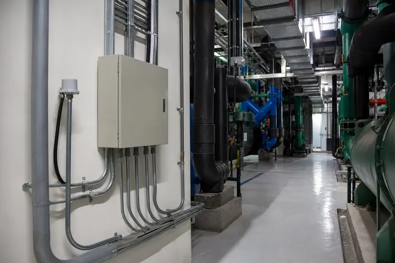 Hotel plant room with closed local controller and pipe-mounted sensing.