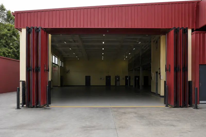 Industrial bi-fold bay with safety sensors and personnel door.
