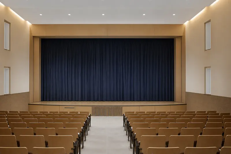 Auditorium column speakers integrated into wall niches.