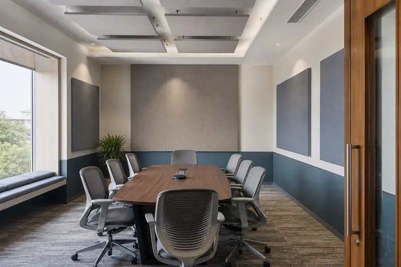 Conference room with ceiling clouds and wall absorbers at reflection points.