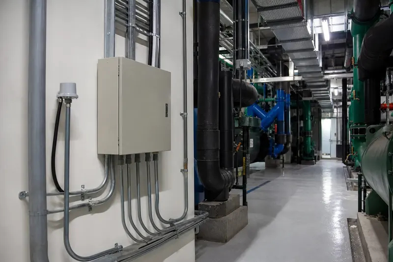 Hotel plant room with closed local controller and pipe-mounted sensing.
