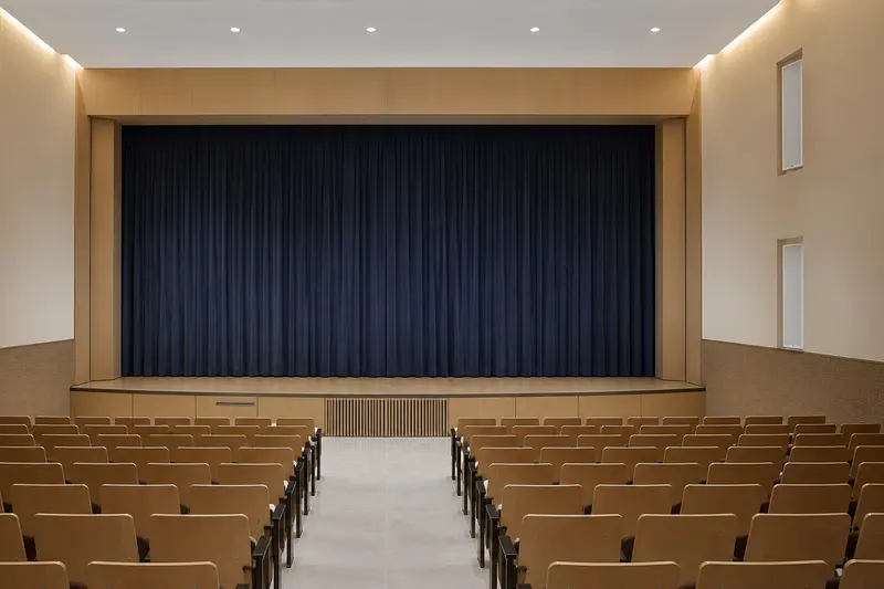 Auditorium column speakers integrated into wall niches.