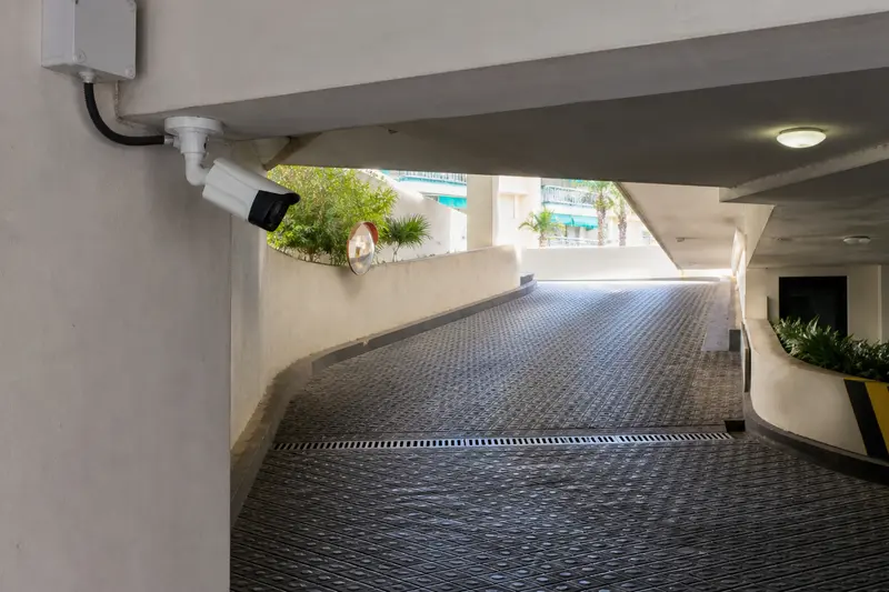 Weatherproof parking-ramp camera aligned along the vehicle approach.