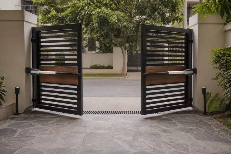 Paired inward-swing residential gate actuators viewed from the compound.
