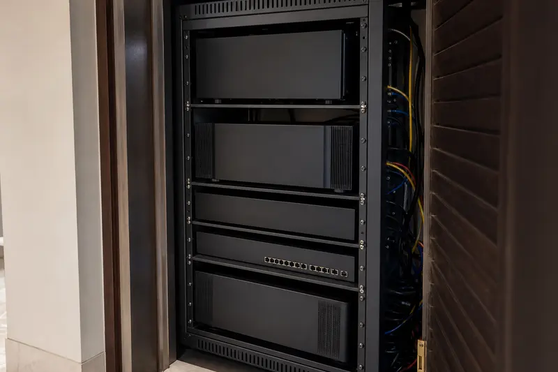 Ventilated blank-face AV rack supports a residential theatre from an adjacent service closet.
