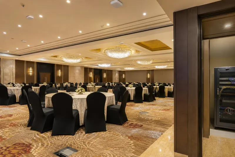 Empty ballroom with distributed ceiling Wi-Fi, floor boxes and adjacent service rack.